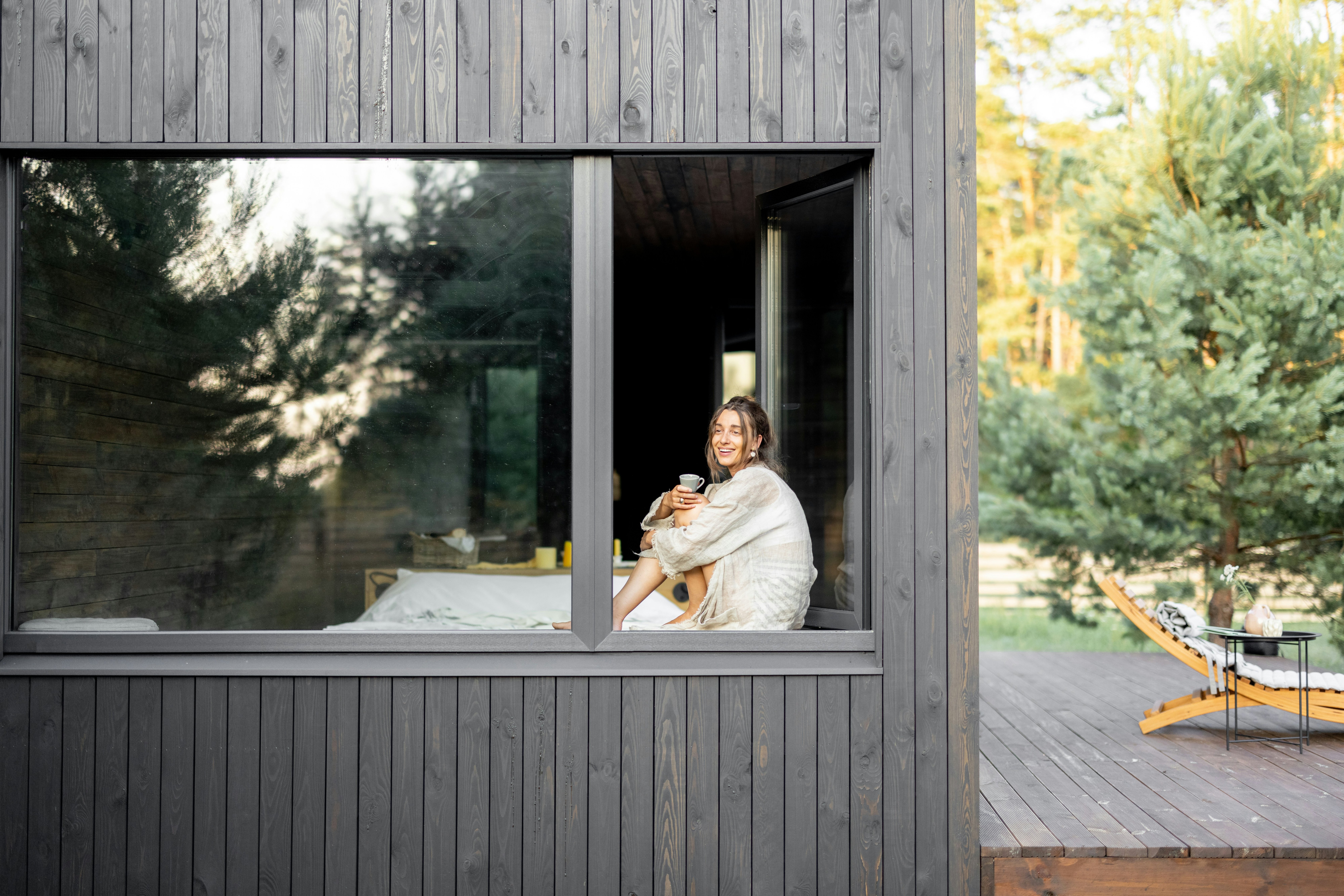 Guest at home in a beautifully designed Airbnb — laughing, coffee in hand