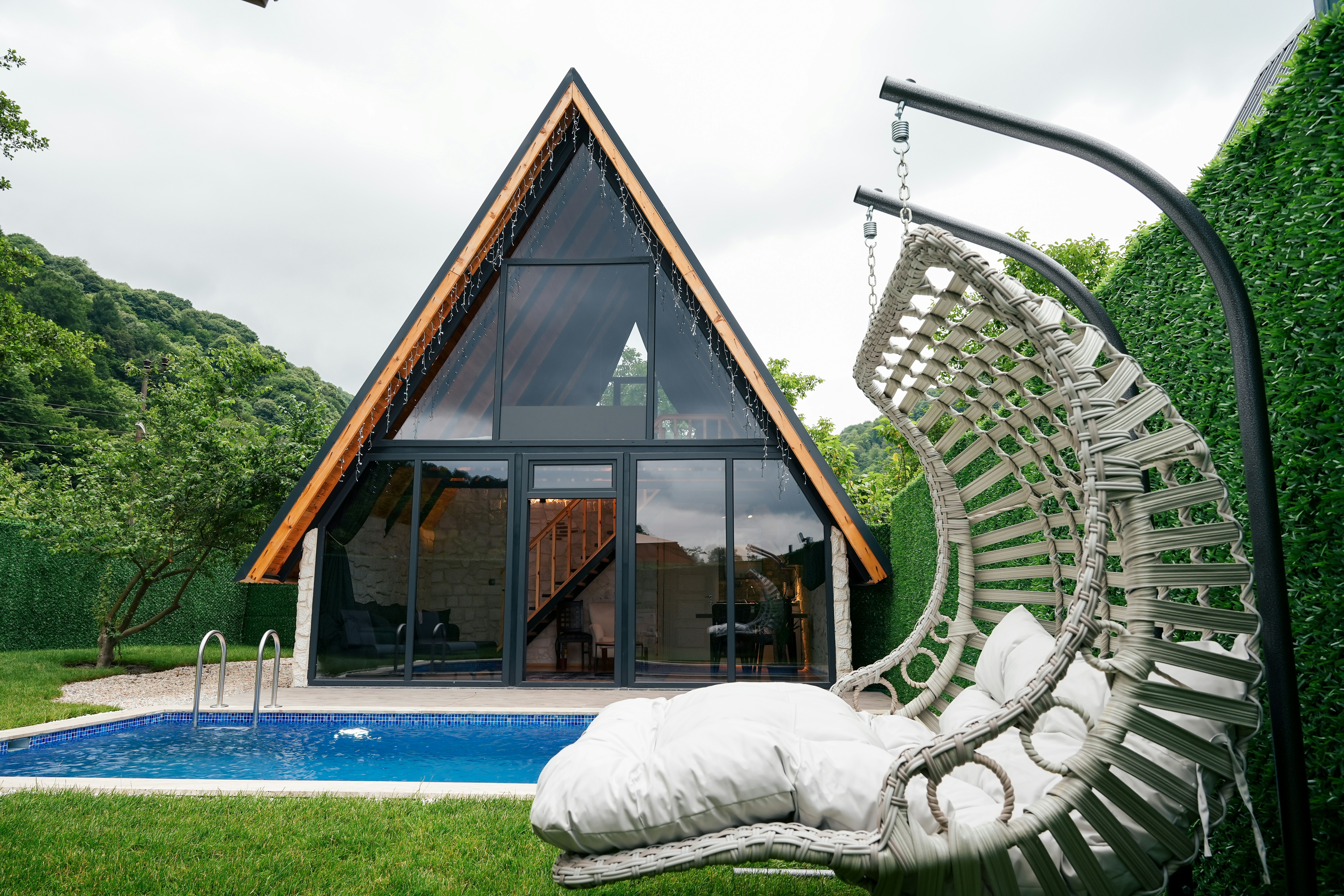 A-frame Airbnb with pool and hanging chair — transformation potential